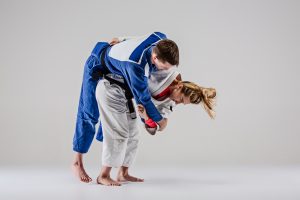 Weilblicher Judoka wirft männlichen Judoka O-goshi