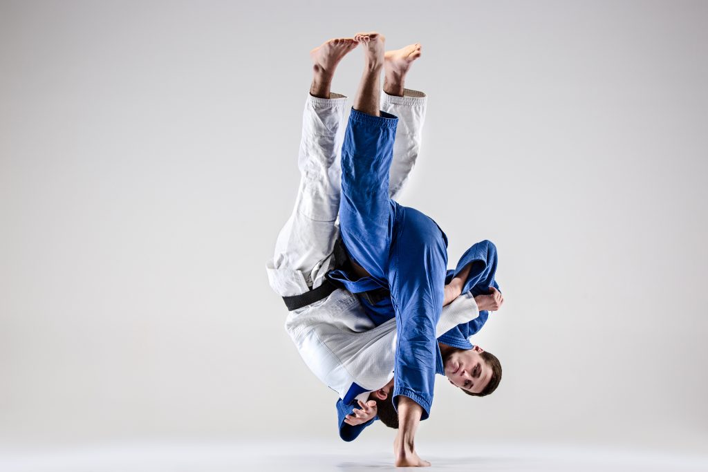Männlicher Judoka wirft männlichen Judoka Uchi-mata